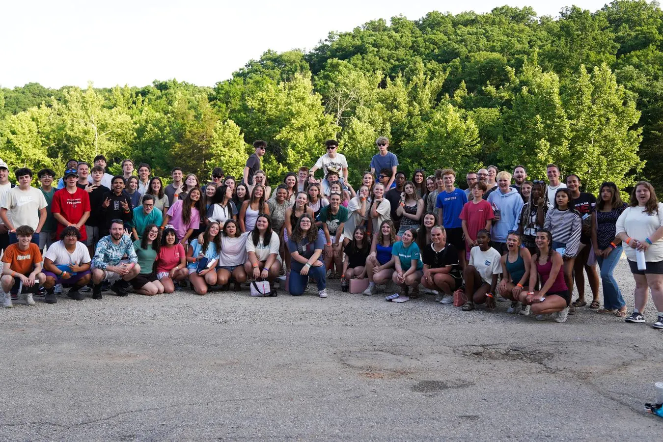 A large group of students posing together outdoors at camp